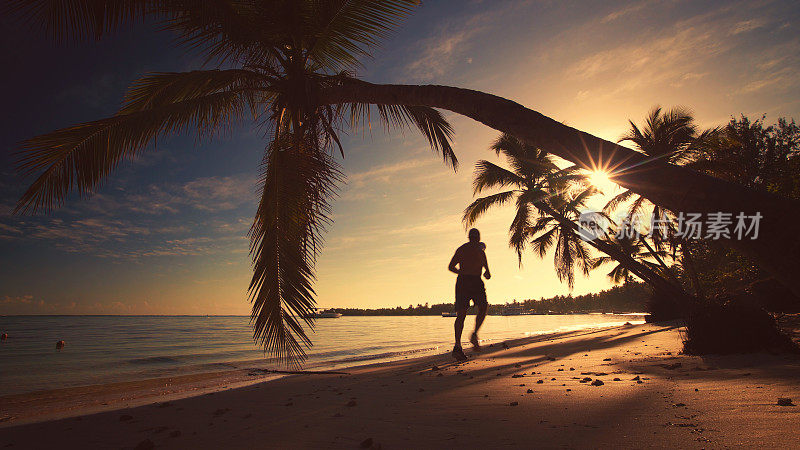 海上日出。男子在Punta Cana热带岛屿海滩上奔跑。